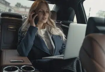 Woman in Gray Business Suit Sitting In A Luxurious Car